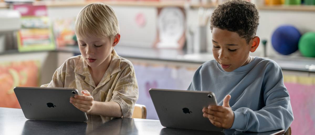 Zwei Schüler arbeiten in einem Klassenraum einer Volksschule mit je einem iPad