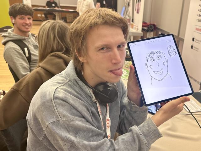 Ein Schüler der Graphischen zeigt die Zunge - genau wie sein von ihm gezeichnets Portrait auf dem iPad, am Stand von Tools at Work auf der Print Fair 2025