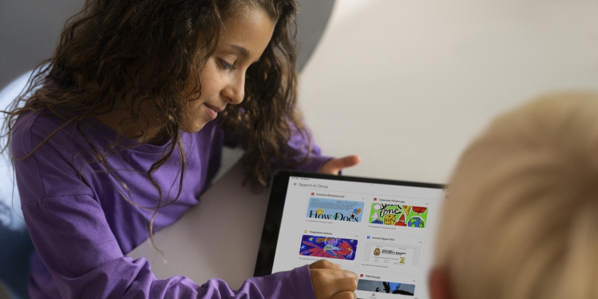 Eine Schülerin zeigt auf ihrem iPad einem Mitschüler verschiedene Apps